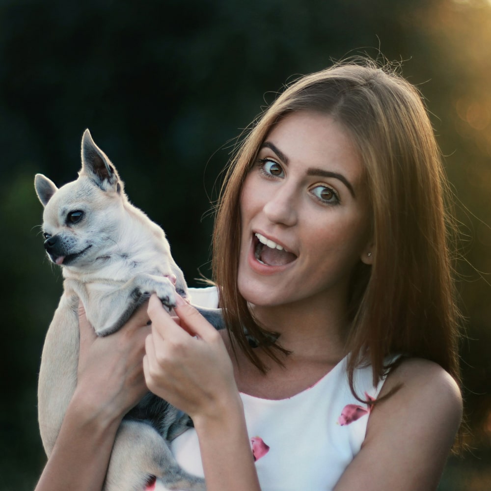 Girl holding a cute puppy in her hands